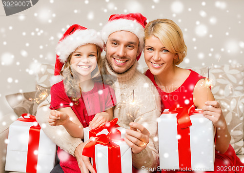 Image of happy family with gifts and sparklers