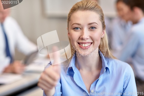 Image of group of smiling businesspeople meeting in office