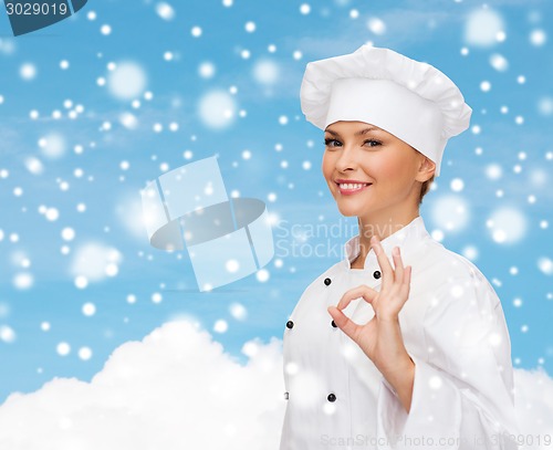 Image of smiling female chef showing ok hand sign