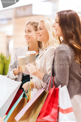 Image of young women with shopping bags and coffee in mall