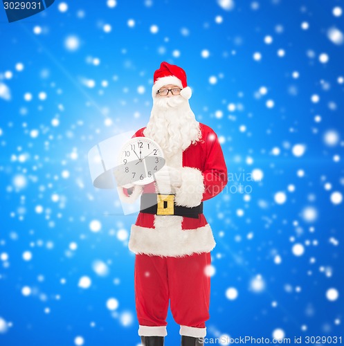 Image of man in costume of santa claus with clock