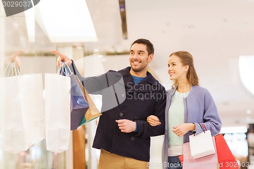 Image of happy young couple with shopping bags in mall