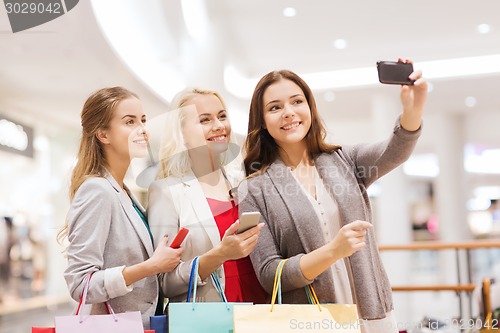 Image of women with smartphones shopping and taking selfie