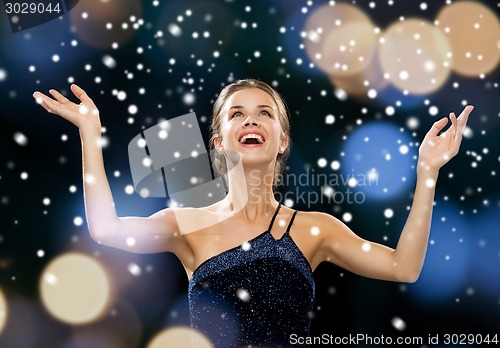 Image of laughing woman rising hands and looking up