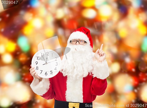 Image of man in costume of santa claus with clock