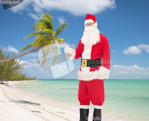 Image of man in costume of santa claus showing thumbs up