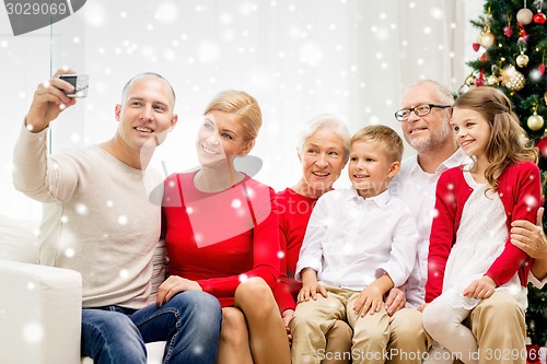 Image of smiling family with camera at home
