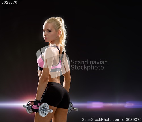 Image of sporty woman with heavy steel dumbbells