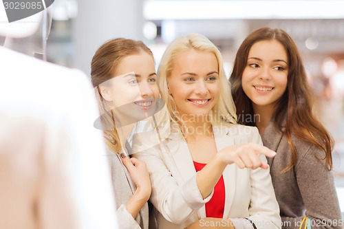 Image of happy young women with shopping bags in mall