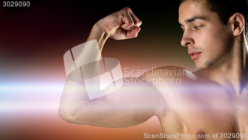 Image of close up of young man flexing and showing biceps