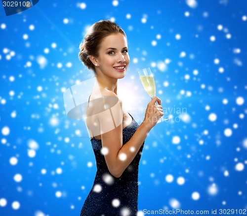 Image of smiling woman holding glass of sparkling wine