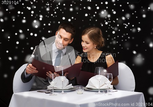 Image of smiling couple with menus at restaurant