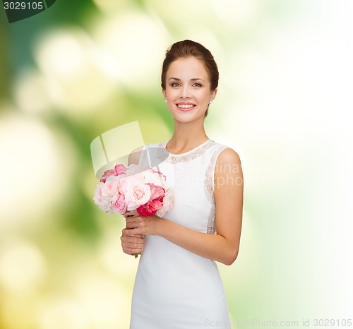 Image of smiling woman in white dress with bouquet of roses