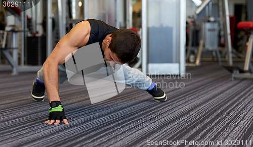 Image of man one arm push-ups in gym