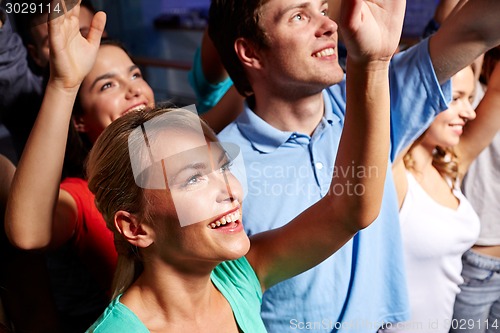 Image of smiling friends at concert in club