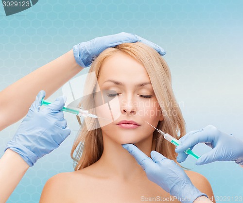 Image of woman face and beautician hands with syringes