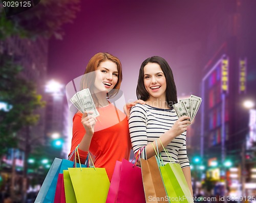 Image of smiling teenage girls with shopping bags and money