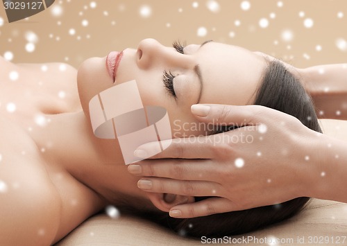 Image of beautiful woman getting face or head massage