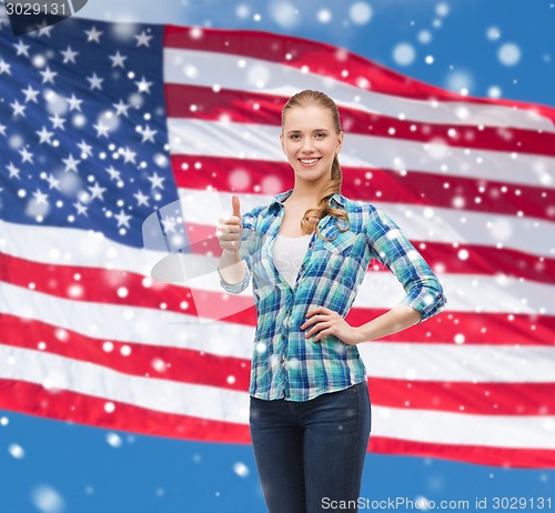 Image of smiling girl in casual clothes showing thumbs up