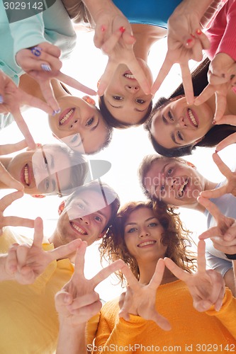 Image of group of smiling teenagers showing victory sign