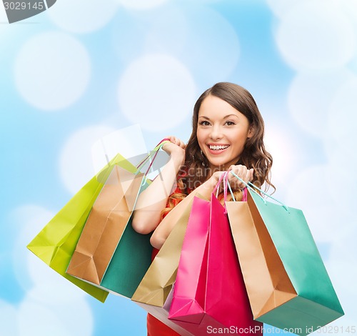 Image of smiling woman with colorful shopping bags