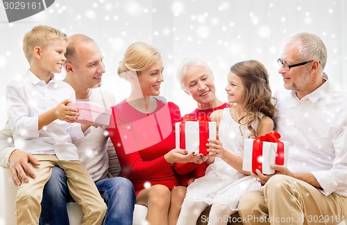 Image of smiling family with gifts at home