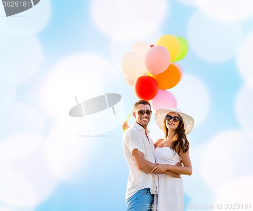 Image of smiling couple with air balloons outdoors