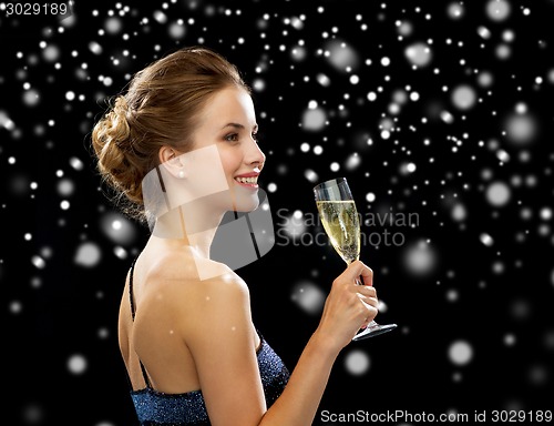 Image of smiling woman holding glass of sparkling wine