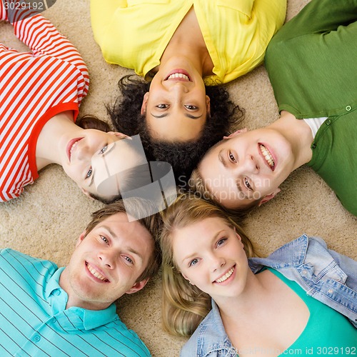 Image of group of smiling people lying down on floor