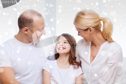 Image of smiling parents and little girl at home