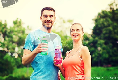 Image of smiling couple with bottles of water outdoors