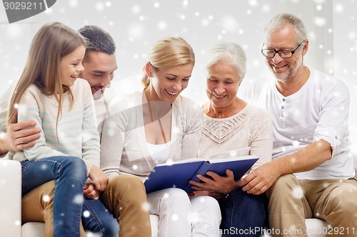 Image of happy family with book or photo album at home