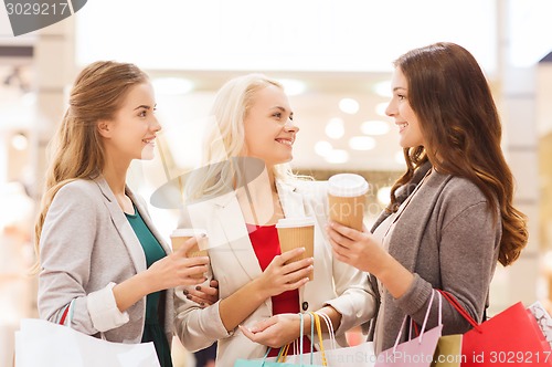 Image of young women with shopping bags and coffee in mall