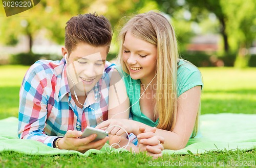 Image of smiling couple with smartphone and earphones