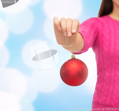 Image of close up of woman in sweater with christmas ball