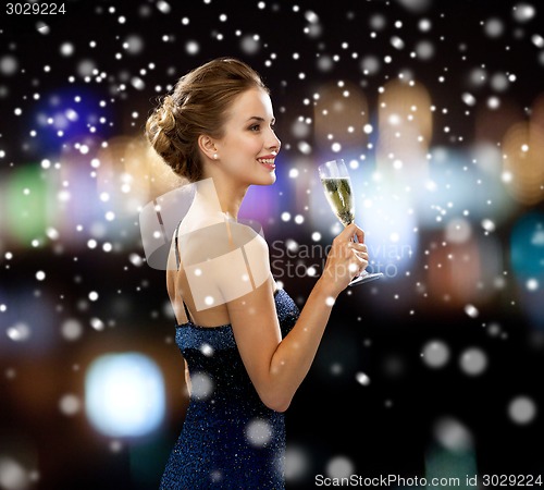 Image of smiling woman holding glass of sparkling wine