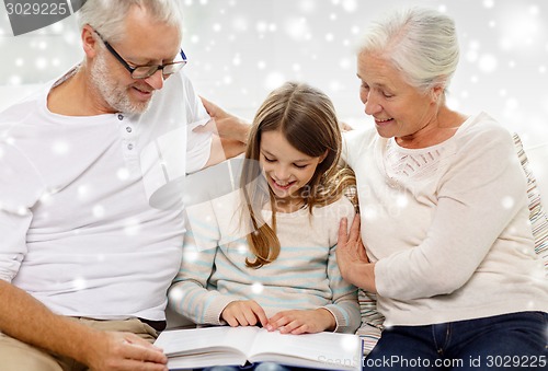 Image of smiling family with book at home