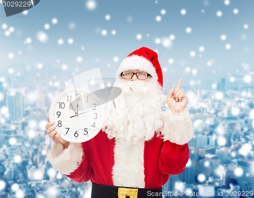 Image of man in costume of santa claus with clock