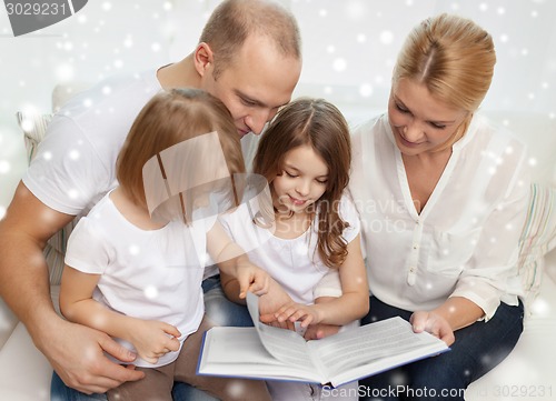 Image of happy family with book at home