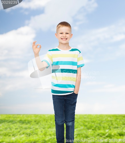 Image of little boy in casual clothes making OK gesture