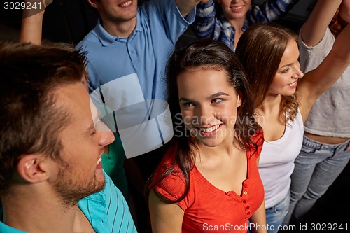 Image of smiling friends at concert in club