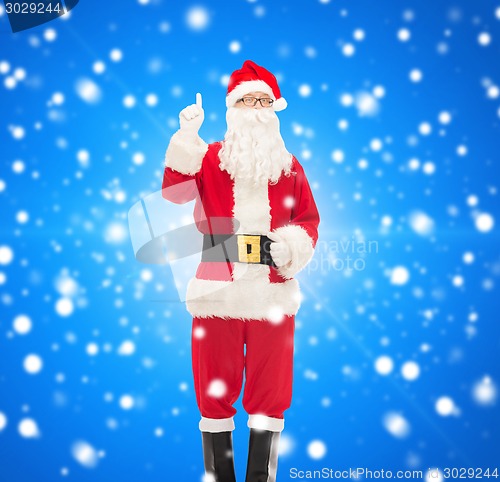 Image of man in costume of santa claus pointing finger up