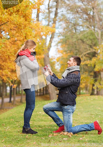 Image of smiling couple with engagement ring in gift box