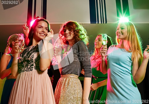 Image of smiling friends with glasses of champagne in club