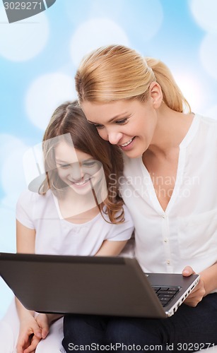 Image of smiling mother and little girl with laptop