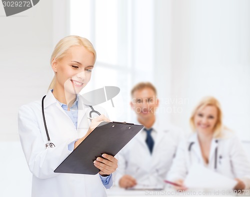 Image of smiling female doctor with clipboard