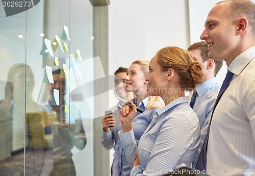 Image of smiling business people with marker and stickers