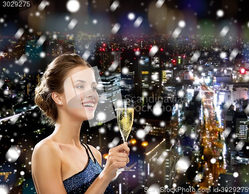 Image of smiling woman holding glass of sparkling wine