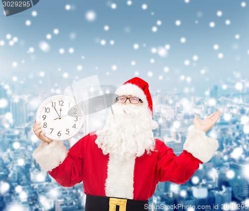 Image of man in costume of santa claus with clock