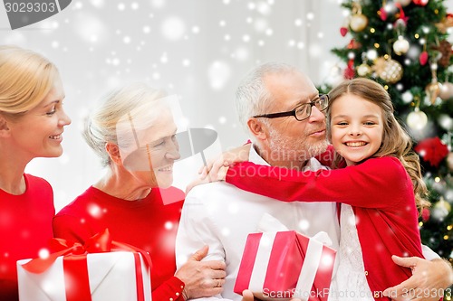 Image of smiling family with gifts at home